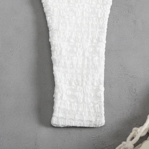 Macro shot of delicate white lace texture and mesh fabric detail on the beach bikini cover-up