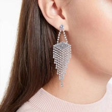 Close-up of elegant silver-tone long fringe earrings with sparkling pavé crystals