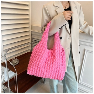 Macro view of soft pink bubble texture fabric on a stylish ruched tote bag for women
