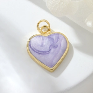 Macro shot of a purple glitter heart charm with 14K gold plated frame and top ring loop