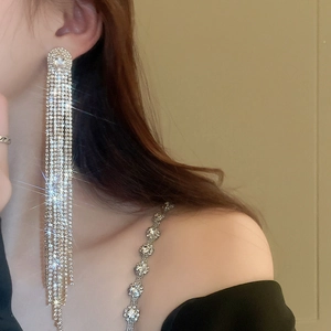 Détail des boucles d'oreilles pampilles argentées de luxe avec zircons scintillants