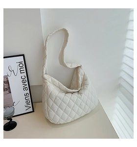 Close-up of white quilted cloud dumpling bag on a desk with a minimalist aesthetic vibe