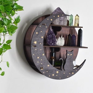 Detail of a round wooden crystal shelf with black cat and golden star moon pattern