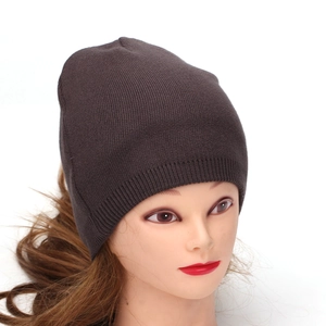 Classic dark brown knitted beanie hat for adults shown on a model in a 45-degree angle