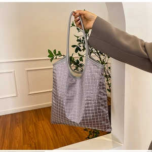 Close-up of lilac gray tote bag featuring textured plaid pattern and sparkling sequins