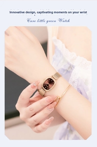 Close-up of rose gold mesh strap quartz watch with oval dial and minimalist bracelet