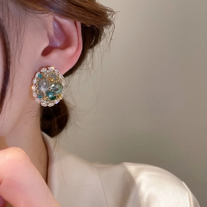 Close-up of vintage geometric hoop earring with crystals and intricate woven metal wire