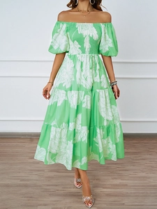 Détail d'une élégante robe à fleurs aux épaules dénudées verte avec de grands motifs blancs