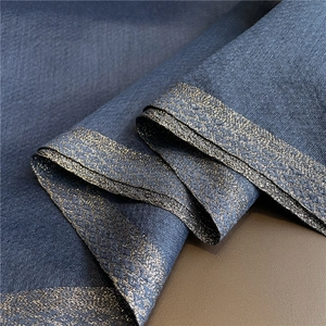 Primer plano de tela azul oscuro de seda y lana con elegante borde trenzado dorado