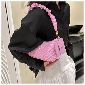 Detail of purple quilted shoulder bag with scrunchie strap and small square pendant