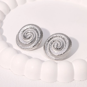 Vue détaillée de boucles d'oreilles spirales argentées avec texture martelée