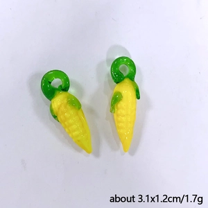 Detail view of yellow glass corn charms with green loops for DIY jewelry, 3.1x1.2cm size