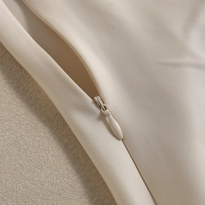 Close-up of seamless invisible zipper detail on premium beige satin sleeveless top