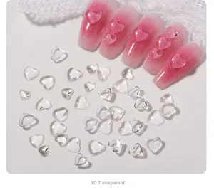 Macro shot of 3D transparent heart charms applied on pink gradient nail art