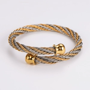 Macro view of gold and silver twisted cable bangle with polished sphere end caps