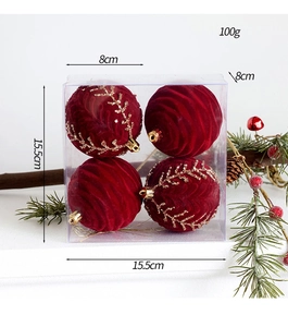 Detail of four 8cm flocked red Christmas balls with gold glitter patterns in a 15.5cm box