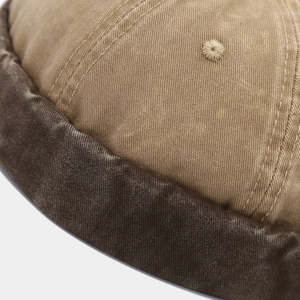 Close-up of khaki twill cotton fabric with brown piping and embroidered eyelet detail