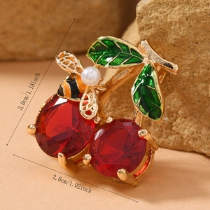 Macro view of cherry brooch with red gemstones and bee detail showing 3.0cm height size