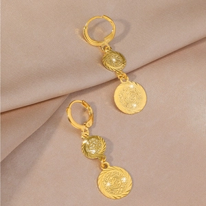 Detailansicht böhmischer Goldmünzen-Ohrringe auf elegantem Champagner-Satin-Stoff