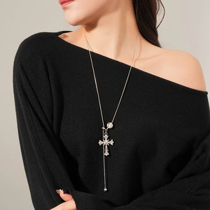 Close-up of a silver cross pendant necklace with a tiger eye stone and round accents