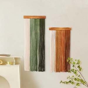 Bohemian handmade fringe wall hanging tapestry with dark wood bar in green and orange tones