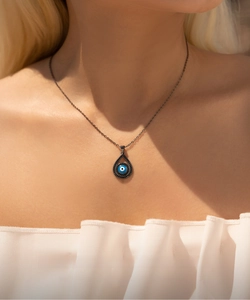 Close-up of S925 silver black ghost evil eye pendant necklace worn by a model