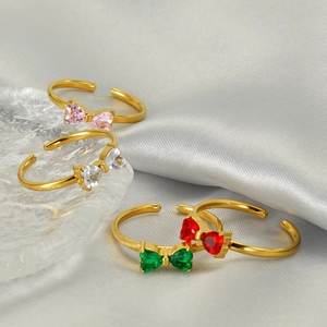 Adjustable gold butterfly rings with colorful gemstones on a silk display