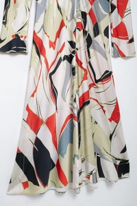 Detail of elegant satin maxi dress featuring an abstract geometric pattern in silk fabric