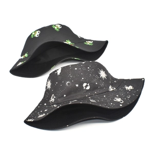 Detail of two black bucket hats featuring frog and celestial patterns in high quality