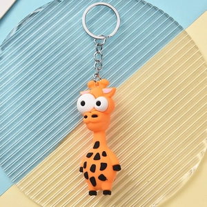Detailed view of an orange cartoon giraffe keychain with big eyes and silver metal ring