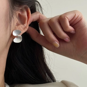 S925 Sterling Silver fan-shaped stud earrings with matte pleated texture on a model