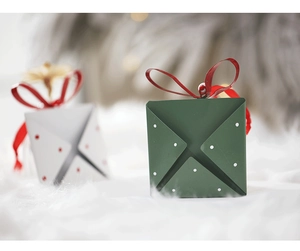 Macro shot of creative envelope-style Christmas gift boxes with red satin ribbon bows