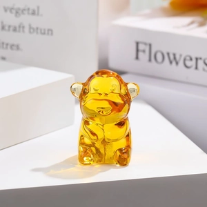 Amber glass monkey figurine ornament with glossy finish on a white creative display