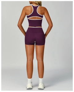 Dettaglio del set sportivo viola con bordi bianchi e design aperto sulla schiena