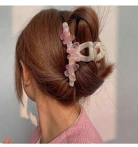 Detail of a jelly gradient butterfly hair claw clip securing a bun on model's hair