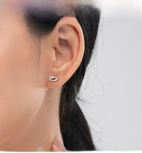 Vue macro des boucles d'oreilles œil porte-bonheur en argent S925 avec cils sur modèle