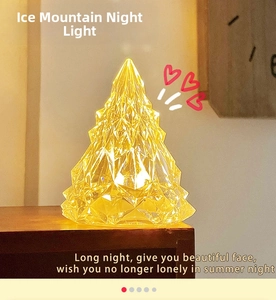 Macro shot of mountain-shaped crystal night light with warm yellow light and faceted texture
