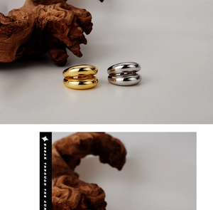 Detail van 925 sterling zilveren en gouden gelaagde geometrische ringen op hout decor