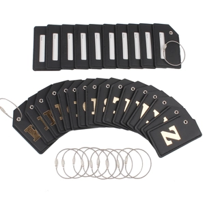 Detailed view of black leather luggage tags with gold lettering and steel wire loops