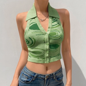 Dettaglio del top a lupetto in maglia verde con colletto polo e trama jacquard astratta