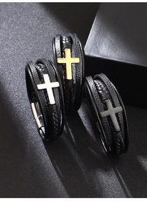 Dettaglio di bracciali in pelle intrecciata con croci in acciaio argento, oro e nero