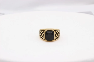 Close-up of vintage gold steel ring with black gemstone and Celtic knot side details