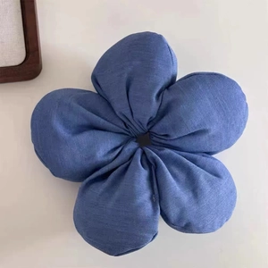 Close-up of a blue fabric flower hair scrunchie with detailed denim-like petal texture