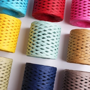 Multi-colored raffia paper ribbons in cylindrical rolls for DIY crafts and gift wrapping