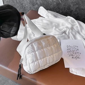 Detail of white quilted crossbody bag with rhombic pattern and matching wide strap