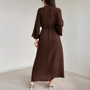 Detail view of the brown maxi dress featuring unique pleated texture and a matching waist belt