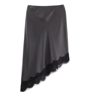 Détail de la jupe en satin gris avec ourlet asymétrique et dentelle noire délicate