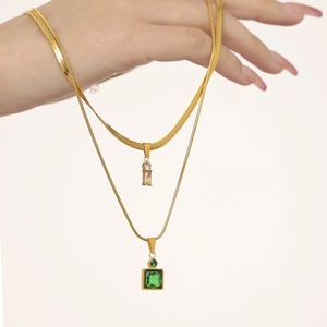 Gold plated layered necklace set with emerald green square stone and zircon pendant