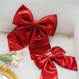 Two red sequin decorative bows for Christmas trees and elegant gift wrapping scenery