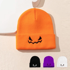 Detail showing various colors of Halloween pumpkin knit beanies with festive embroidery